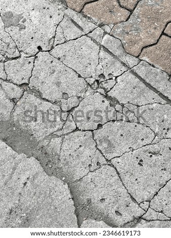 a photography of a fire hydrant sitting on the side of a road, a close up of a fire hydrant on a cracked sidewalk.