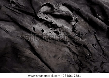 a photography of a black cloth with holes and a horse's head, image of a black cloth with holes in it.