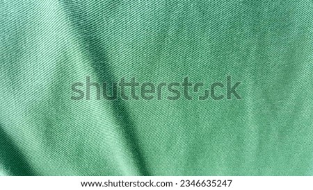 a photography of a green shirt with a white stripe on it, velvet fabric with a green color.