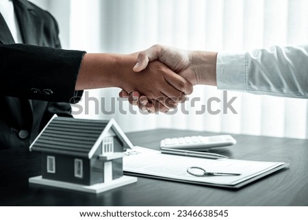Estate agent and client are shaking hands after good deal home loan after discussing and signing contract to rent a house with approved insurance form. Royalty-Free Stock Photo #2346638545
