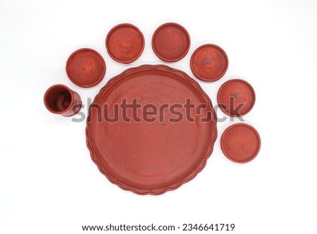 DECORATIVE CLAY THALI WITH BOWL AND GLASS ISOLATED ON WHITE WITH SELCTIVE FOCUS. TOP VIEW. Royalty-Free Stock Photo #2346641719