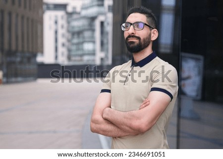 Portrait of Arab Arabian young handsome happy muslim bearded man with beard in casual clothes, islamic person, university or college student or successful businessman outdoors at campus, smiling