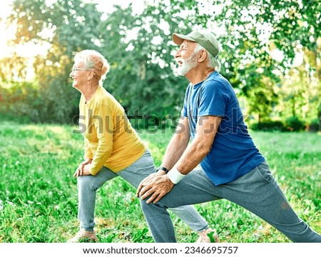 Smiling active senior people stretching and exercising together in the park, healthy lifestile workout fitness training class Royalty-Free Stock Photo #2346695757