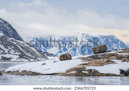 Still water with reflection, and brash ice; Sptizbergen; Two erratic boulders; Spitzbergen