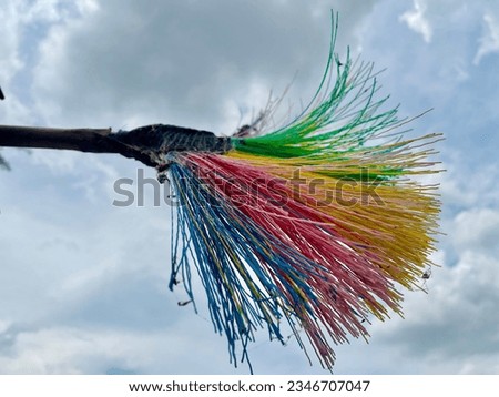 A rainbow broom is under the sky