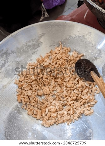 Dried shrimp on a pan that will be roasted to reduce the water content in it.  Dried shrimp will be used as an ingredient in various Asian dishes