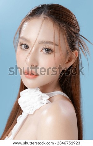 Young Asian beauty woman model long hair with natural makeup look on face and perfect clean skin on isolated blue background. Facial treatment, Cosmetology, Spa, Aesthetic, plastic surgery.