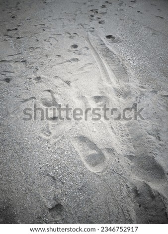 There are many footprints on the surface of the beach sand