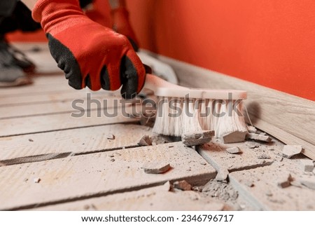 Worker cleaning after cuts concrete floor for electrical cable. Install underfloor heating. Royalty-Free Stock Photo #2346796717