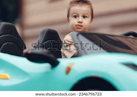 Little novice driver, happy child boy driving car outdoor. Royalty-Free Stock Photo #2346796723