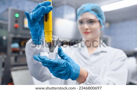 Bottling factory worker inspecting quality of water bottles before shipment. Reverse osmosis system used in plant. water purity and maintaining quality control in bottling process. High quality photo Royalty-Free Stock Photo #2346800697
