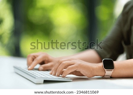 Cropped of woman working from home distance office on pc, hands with smart watch typing on modern wireless keyboard. Business lady using computer, send emails, chatting with client, copy space Royalty-Free Stock Photo #2346811069