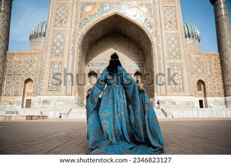 Uzbek woman in traditional dress in Registan square Samarkand, Uzbekistan Royalty-Free Stock Photo #2346823127