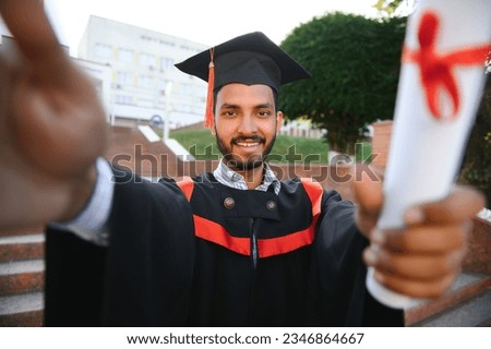 indian male graduate taking selfie.