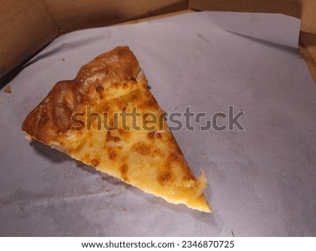 Cheesy Pizza slice last one left in the pizza box

