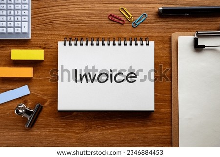 There is notebook with the word INVOICE. It is as an eye-catching image.