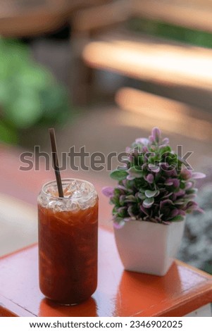 iced black coffee in a beautiful glass on a wooden table
