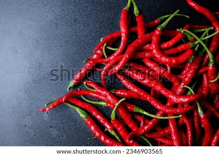 Curly red chili on a black background. natural red chili background with copy space. perfect for background, wallpaper, photo illustration, or any design purposes. 