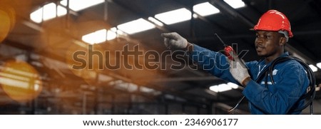 african american electrician worker with electric wire using and talking to walkie-talkie radio in factory with copy space Royalty-Free Stock Photo #2346906177
