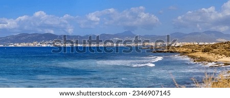 Large high-quality panorama in high resolution, background screensaver for Windows desktop. Beautiful Spanish coastline with distant blue mountains. Blue waves approach the yellow sandy shore 