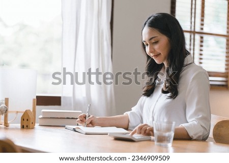Woman works at home sitting at her desk with her laptop