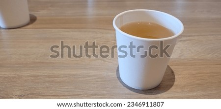 jasmin tea in mini paper cup on wood table Royalty-Free Stock Photo #2346911807