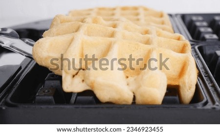  Waffles, with berries, on a white table, breakfast, no people, horizontal  3d  honey pouring on thick and crispy toaster waffles with falling berry fruits over yellow