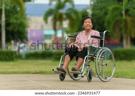 senior woman sitting in wheelchair at the park