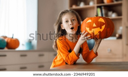 Cute little child girl with carving pumpkin. Happy family preparing for Halloween.  Royalty-Free Stock Photo #2346949201