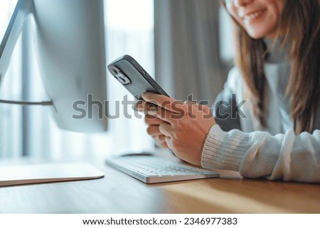Close up - Unrecognizable cheerful young woman reading a message on a smartphone, Happy female using mobile phone to send text messages working or playing social media.