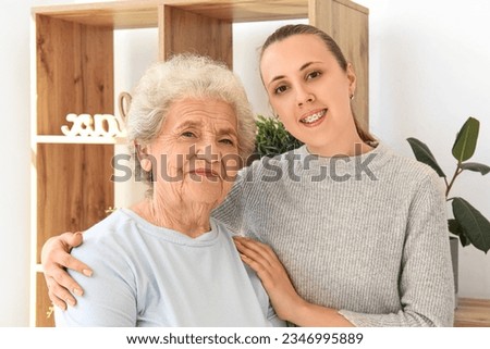 Senior woman with her granddaughter hugging at home