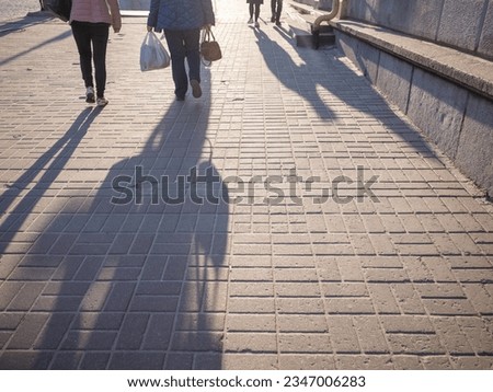 back and shadow of people walking on the sidewalk in the evening in capital kyiv