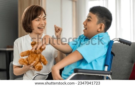 Portrait of enjoy happy love family asian mother playing and carer helping look at disabled son child sitting in wheelchair moments good time at home.disability care concept Royalty-Free Stock Photo #2347041723