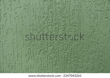Close shot of green wall with stucco worm finish