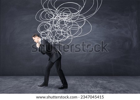 Stress burden and mental problems concept with tired businessman carrying heavy tangled line on blackboard background Royalty-Free Stock Photo #2347045415
