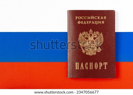 Passport of a citizen of the Russian Federation, on a background of the national flag (copy space, flat lay)