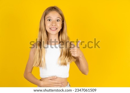beautiful caucasian kid girl wearing white  shirt happy positive smile hands on belly show thumb-up fine healthy