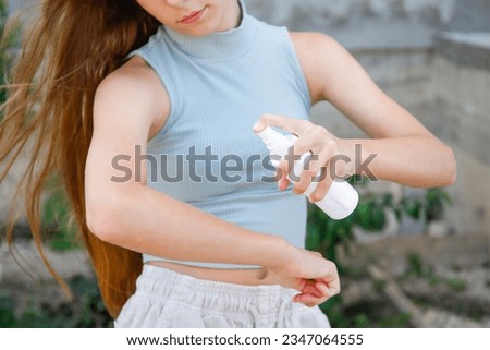 A teenager applies insect spray on his hand. The concept of prevention from mosquito bite. Royalty-Free Stock Photo #2347064555