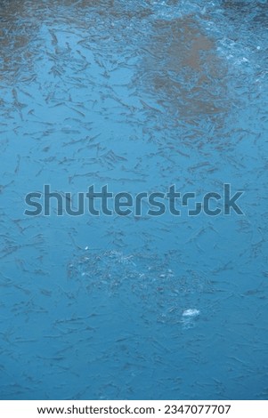 Cracked ice on a frozen lake. The natural texture of winter ice with white bubbles and cracks on a frozen lake. transparent lake covered with ice in winter. Abstract bright background