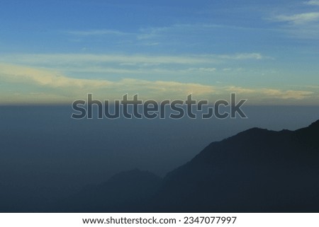 Photo illustration of a mountain landscape covered in milky white clouds