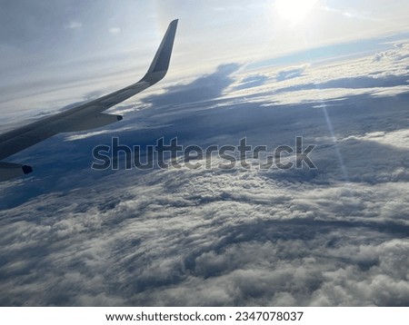 surrounded by fluffy clouds. A beautiful picture taken from airplane window seat.