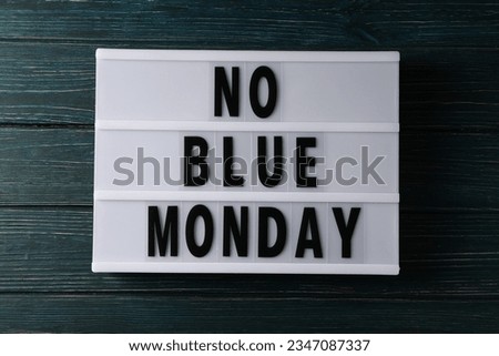 Text No Blue Monday on dark blue wooden background, top view