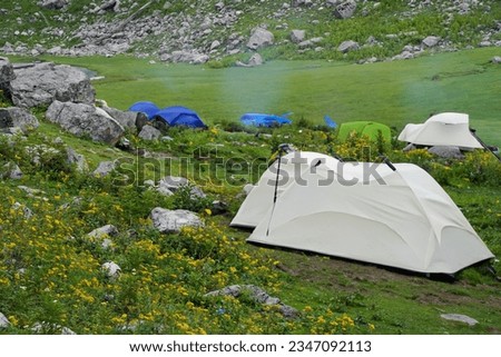 camping tent among mountains. Adventure and exploration, conquering adversity. Royalty-Free Stock Photo #2347092113