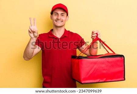 young handsome guy smiling and looking friendly, showing number two. pizza delivery concept
