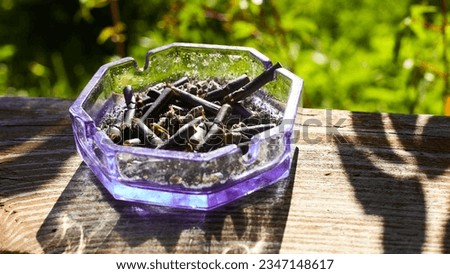 ashtray with black cigarettes on the street