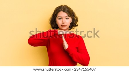 pretty hispanic woman looking serious, stern, angry and displeased, making time out sign