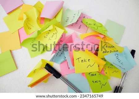 Notebook and notebook paper sheets with quotes on white background with masking tape and paper clips.