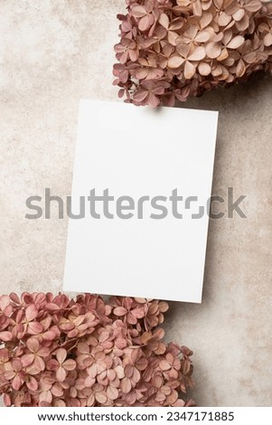 Wedding invitation card mockup with hydrangea flowers on beige background, blank card with copy space