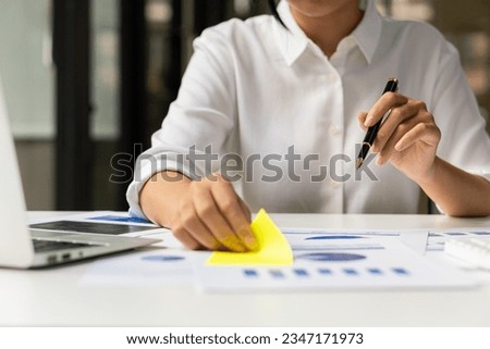 Female accountant analyzing charts, graphs, computer, investment tablet and pressing calculator button above document. Accountants, accountants, clerks, bank consultants and auditors. close-up photo