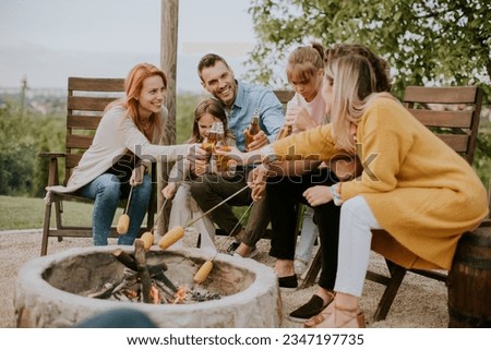 Group of friends having good time and baking corns in the house backyard Royalty-Free Stock Photo #2347197735